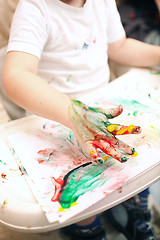 Image showing Boy painting with finger-paints