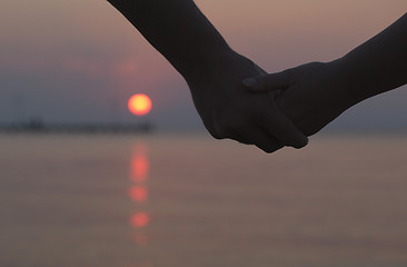 Image showing Couple holding hands at sunset