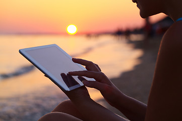 Image showing Woman using pad outdoor at sunset