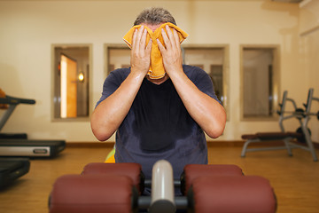 Image showing Man wiping face with a towel after training