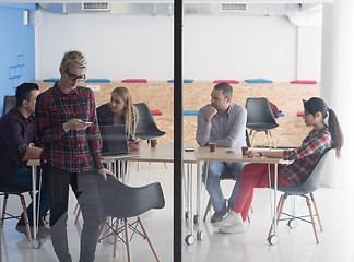 Image showing business woman at office speaking by phone  team on meeting in b