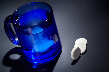 Image showing Tablet dissolving in a blue glass of water.