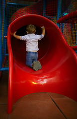 Image showing Boy is sitting at the slide hole