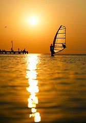 Image showing Silhouette of surfer at sunset passing by