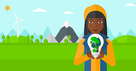 Image showing Woman with lightbulb and trees inside.