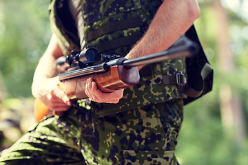 Image showing close up of soldier or hunter with gun in forest