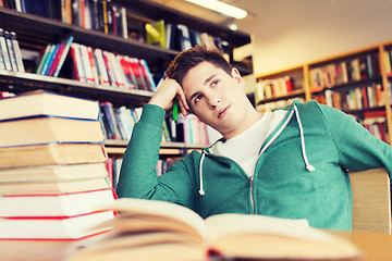 Image showing bored student or young man with books in library