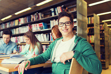 Image showing happy student boy reading books in library