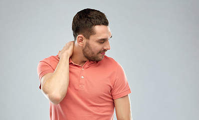 Image showing unhappy man suffering from neck pain