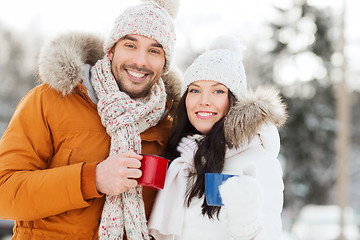 Image showing happy couple with tea cups over winter landscape