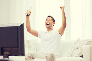 Image showing smiling man watching sports at home