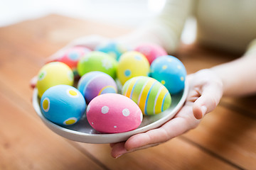 Image showing close up of woman hands with colored easter eggs