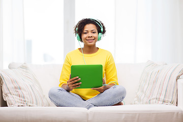 Image showing happy african woman with tablet pc and headphones