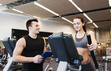 Image showing woman with trainer exercising on stepper in gym