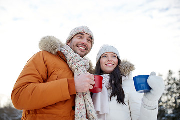 Image showing happy couple with tea cups over winter landscape