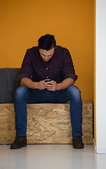 Image showing man in crative box working on smart phone