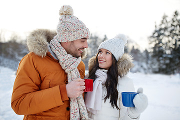 Image showing happy couple with tea cups over winter landscape