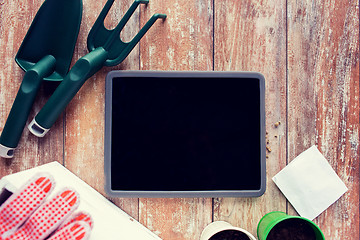 Image showing close up of tablet pc and garden tools on table