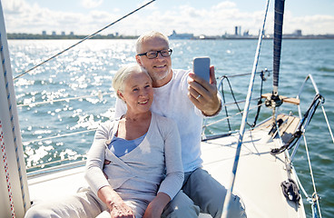 Image showing seniors with smartphone taking selfie on yacht