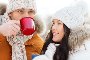 Image showing happy couple with tea cups over winter landscape