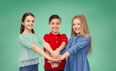 Image showing happy children with hands on top over green board