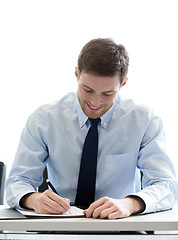 Image showing smiling businessman signing papers in office