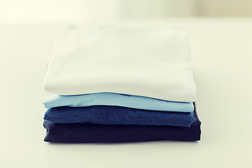 Image showing close up of ironed and folded t-shirts on table