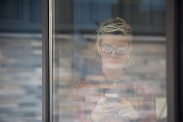 Image showing business woman at office speaking by phone  team on meeting in b