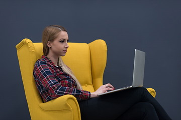 Image showing startup business, woman  working on laptop and sitting on yellow