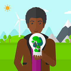 Image showing Man with lightbulb and trees inside.