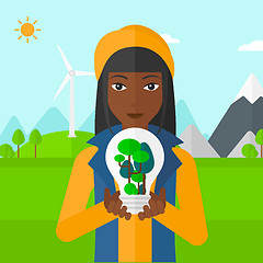 Image showing Woman with lightbulb and trees inside.