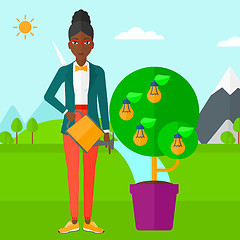 Image showing Woman watering tree with light bulbs.