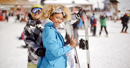 Image showing Man flirting with woman holding snowboard