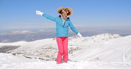 Image showing Happy adult in ski clothes waving arms