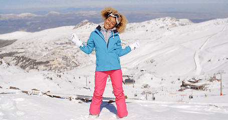 Image showing Single woman in ski clothes waving arms