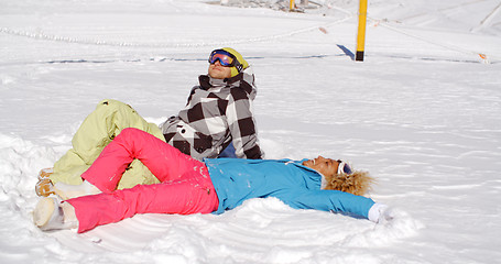 Image showing Couple resting on hill after skiing