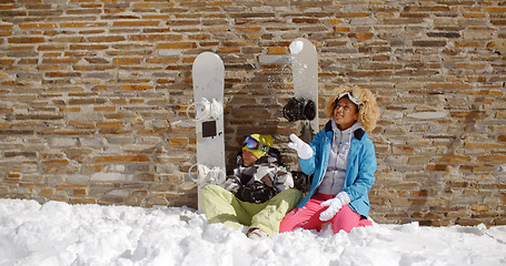 Image showing Snowboarding friends sitting in pile of snow