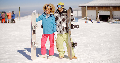 Image showing Happy young couple posing with their snowboards