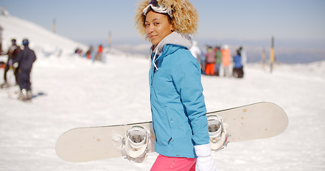 Image showing Trendy young woman carrying her snowboard