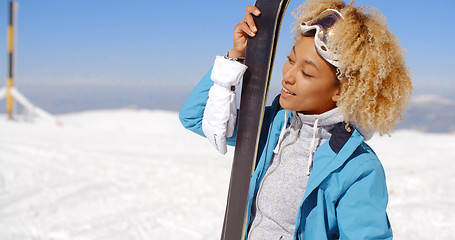 Image showing Beautiful woman holding skis with copy space