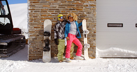 Image showing Cute couple leaning against ski resort garage