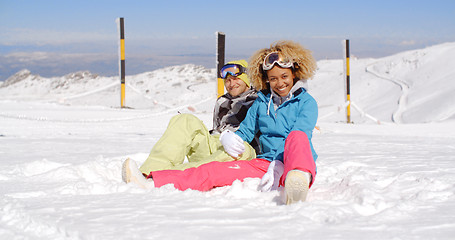 Image showing Couple sitting in snow on ski slope