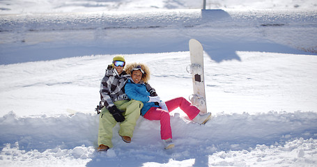 Image showing Happy young couple sitting on a deep shelf of snow