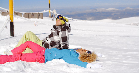 Image showing Couple resting on hill after skiing