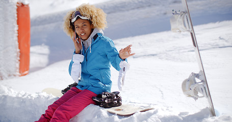 Image showing Laughing woman chatting on her mobile in snow