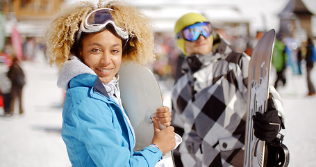 Image showing Cute woman holding snowboard on ski slope