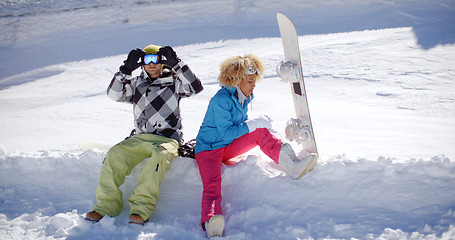 Image showing Young couple getting ready to go snowboarding