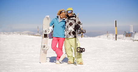 Image showing Happy young couple posing with their snowboards
