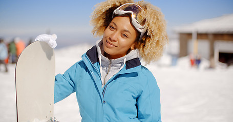 Image showing Gorgeous trendy young woman with her snowboard