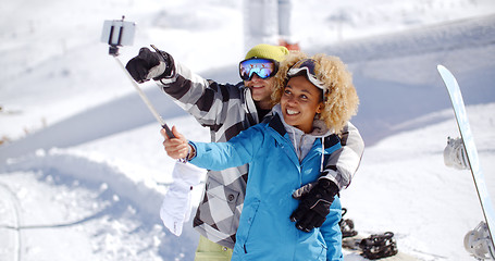 Image showing Fun young couple posing in the snow for a selfie